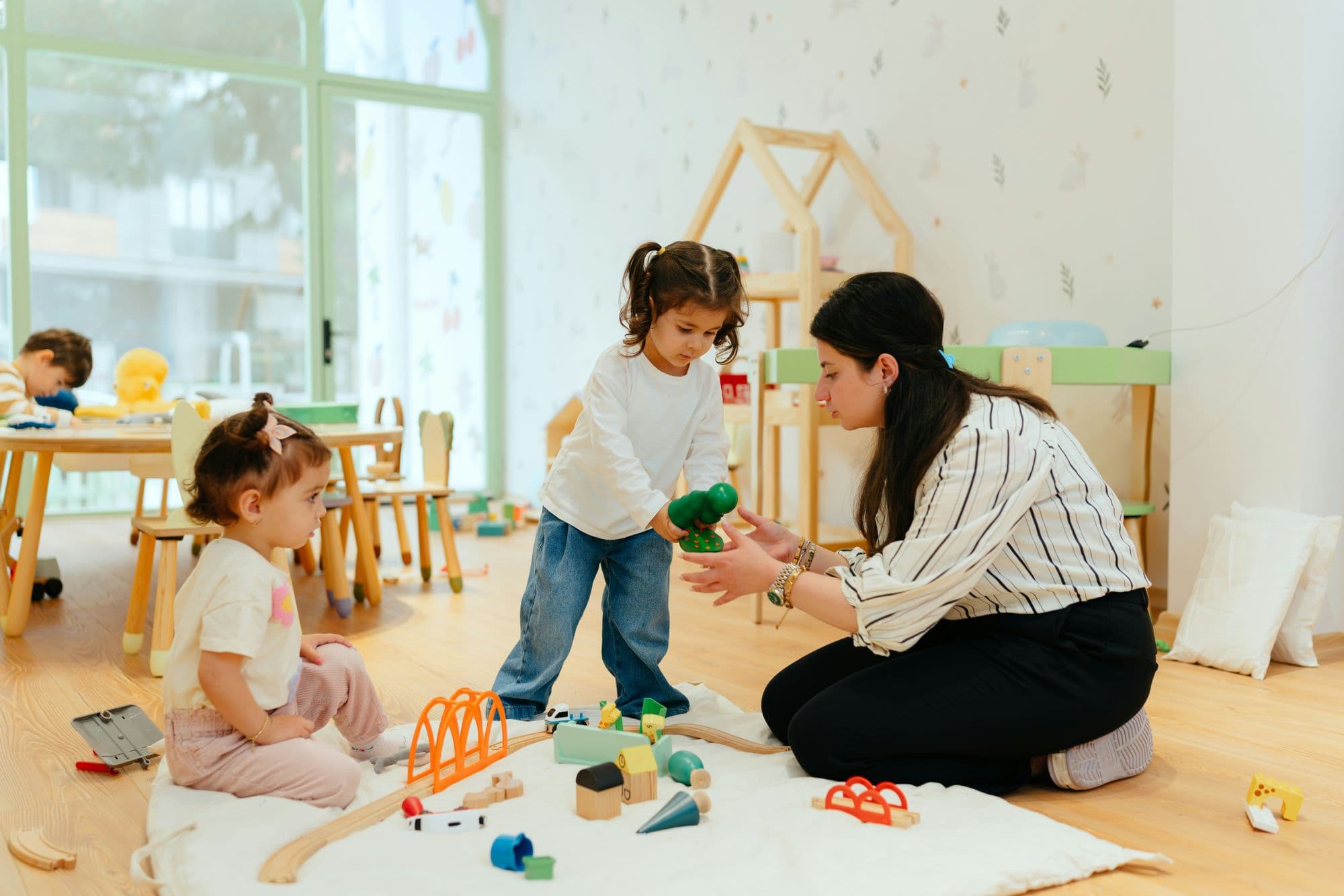 Une professionnelle et des enfants dans une crèche Les Petits Chaperons Rouges